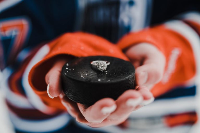 Edmonton Engagement Session in Snowy Weather with a Ring on Hockey Puck and Oiler's Jersey